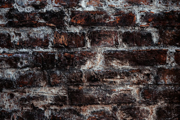 old dark brown salt-covered brick wall in an old European city