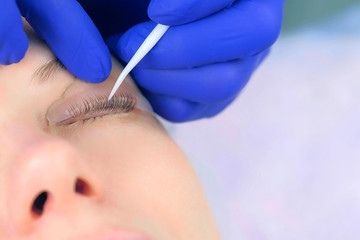 Cosmetologist bending lashes with needle into curlers, lift eyelashes laminaton procedure in beauty...