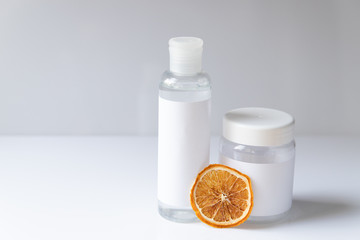 Cosmetic bottle for liquid, cream, gel, lotion. Hand sanitizer. Organic natural science beauty product. Battle with slice of orange