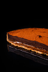 Tiramisu layered with crumbled buttered biscuit, cocoa moose coated with mixed dark chocolate and coffee. Confectionery photography concept.