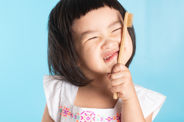 Cute Asian girl holding a toothbrush to clean her teeth and copy space.