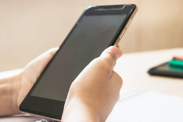 A child is learning distance learning lessons on a mobile phone.