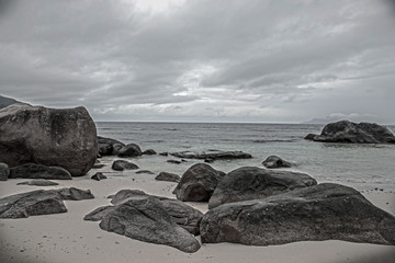 Fototapeta na wymiar Beautiful big stones on the beach with ocean view, beautiful rainy clouds on the ocean .