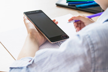 A child is learning distance learning lessons on a mobile phone.