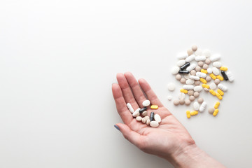 Hand with pills on a white background. Copy space.