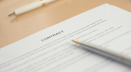 A contract on the desk. A pen and contract on the table.