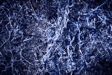 Black background, ash from burnt, dry grass.