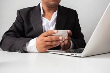 Businessman holding a coffee cup on the white table at the office ,Concept: planning meeting working professional,
beverage cafe breakfast for working, looking space to a morning lifestyle workplace 