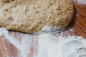 Overhead view of the hands of an adult man kneading dough in a table wooden
