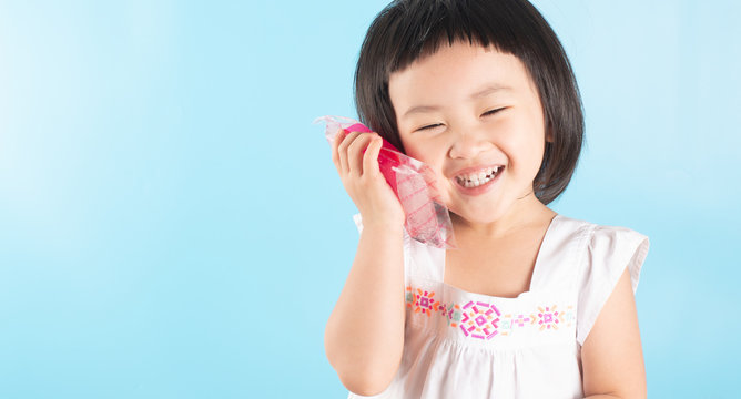 Cute Asian girls are using ice bags. Apply on the cheek to reduce toothache.