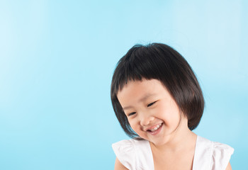 Happy asian cute girl on blue background.