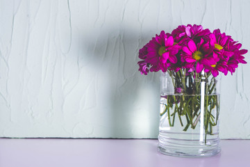 burgundy chrysanthemums in a transparent vase on a table
