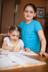 Older sister helping   younger sister with her studies