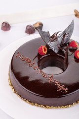 Chocolate cake with chocolate glaze and chocolate crumb with fresh raspberry