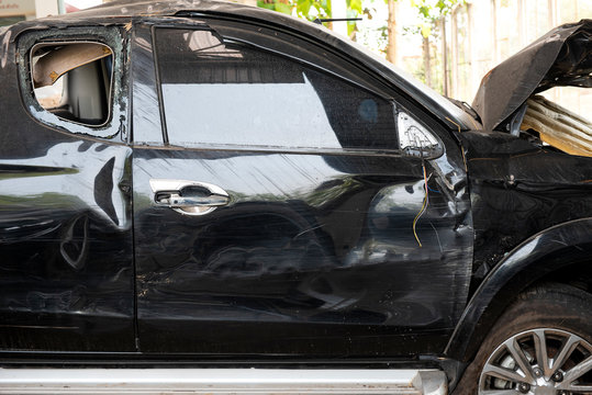 Damaged black car after the accident close-up photo or Car crash accident damaged background. Front side of car was demolished due to a accident, vehicle