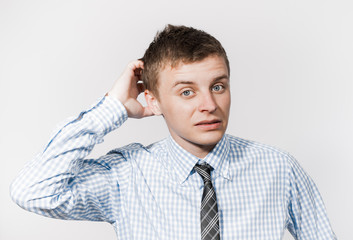 Young businessman scratches his head