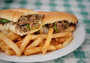Steak sandwich with french fries on white plate side view