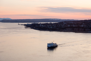 Aerial view of the first ferry of the day crossing the St. Lawrence River from Lévis during an early morning sunrise, Quebec City, Quebec, Canada