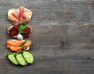 Variety of sandwiches for breakfast, snack, appetizer. On a wooden table, copy space, top view