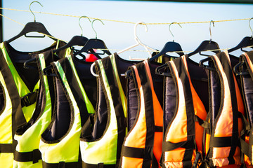 old shabby lifejackets hanging on the beach by the tent with extreme water hire