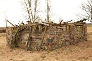 Fototapeta premium Old stone barn almost fallen with wooden roof top cover