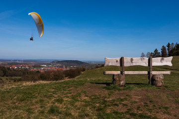 wooden bench with paraglider in front of goslar harz mountains germany