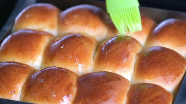 Close Up Of Baked Bread And Apply Butter On Top By Using Kitchen Brush With Melted Butter. Fresh Homemade Of Plain Bread From Oven In Slow Motion. Cooking, Formulation And Decorated Concept.