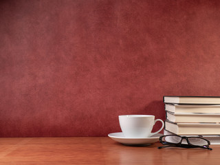 cup, glasses and books on wooden table