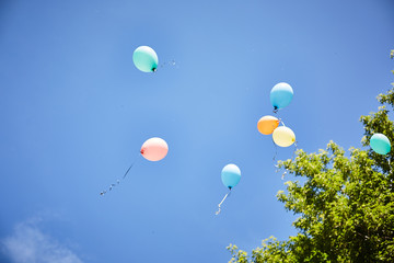 balloons fly away on a background of blue sky.