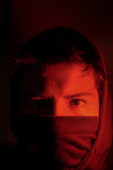 Young man with mask with red light in times of pandemic