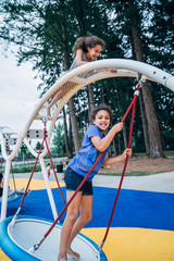Girl swinging on swing in modern city park