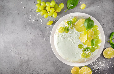 cake, pie  with grapes, lime slices,  green Basil on a gray , baking, cream,  top view, citrus