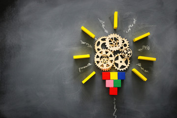 Education concept image. Creative idea and innovation. Wooden gears light bulb metaphor over...
