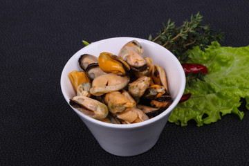 Pickled mussels in the bowl served pepper, garlic and salad