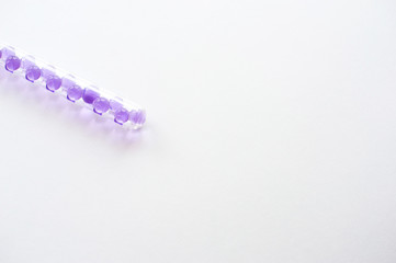 Bright purple hydrogel of a round shape in a transparent flask with a stopper. Macro-gel balls. The concept of purity, purity, transparency, ideal and perfection. Beautiful classic abstract holiday 