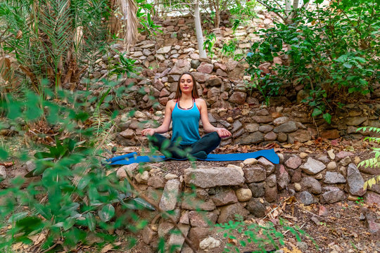 Young woman practicing yoga in the parck