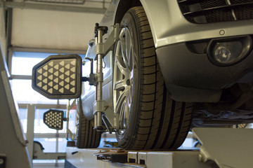 Car on stand with sensors on wheels for wheels alignment camber check in workshop of Service station	