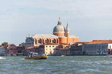 Fototapeta na wymiar Water channels of Venice city. Church of the Santissimo Redentore and Galleria Il Redentore buildings are on Grand Canal in Venice, Italy.