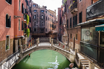 Fototapeta na wymiar Bridge over the canal in a quiet street in Venice