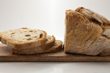 freshly cut homemade bread on a wooden board.
