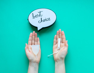 Woman hands comparing menstrual cup with a tampon