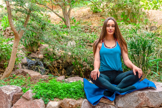 Young woman practicing yoga in the parck