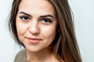 Portrait of beautiful caucasian young woman with perfect skin and makeup on white background, close up.
