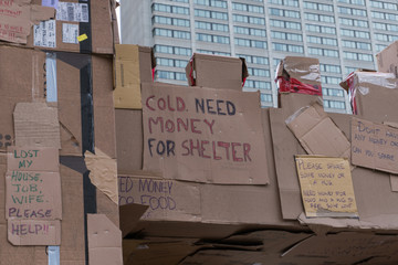 Homeless person sign cold need money for shelter written on cardboard tagged on wall for display...