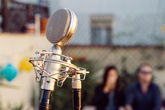 Detail of a vintage old microphone isolated on a festival background. Live music concept. Intimate concert abut to start. Music outdoors concept.