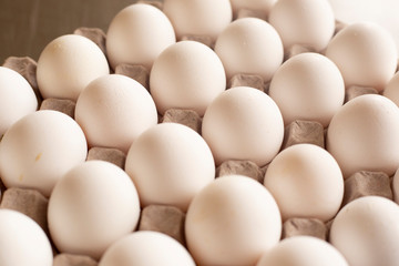 Fresh organic white eggs on the kitchen table - egg carton
