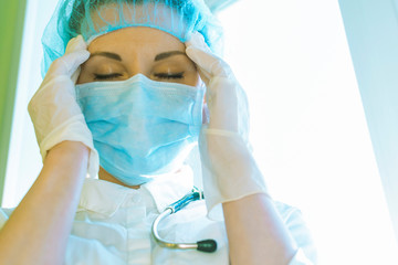 Fototapeta premium A woman doctor massages her temples because of a headache, bad health.