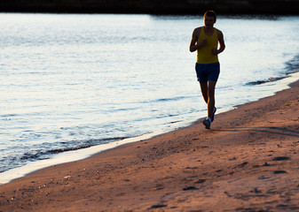 Fototapeta na wymiar Man running on the beach at sunrise