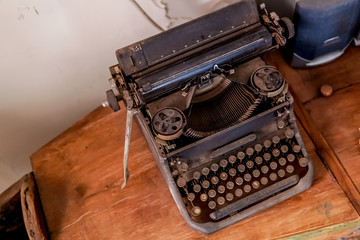 Fototapeta na wymiar a dusty black antique typewriter on the table