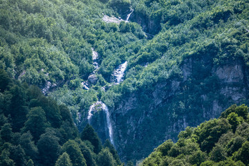 Green mountains with a high waterfall in spring or summer